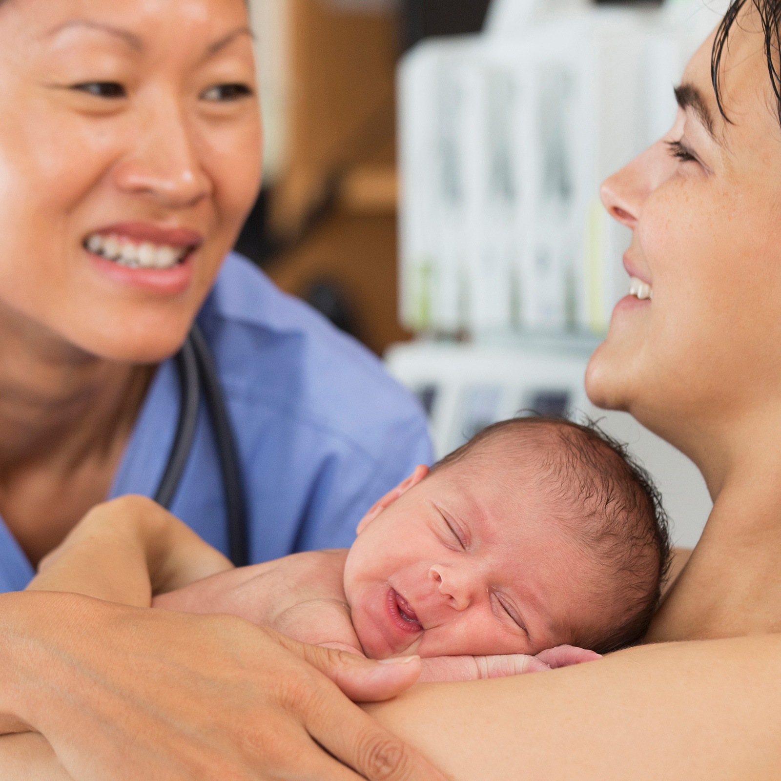 An nurse with a smiling mother and her newborn